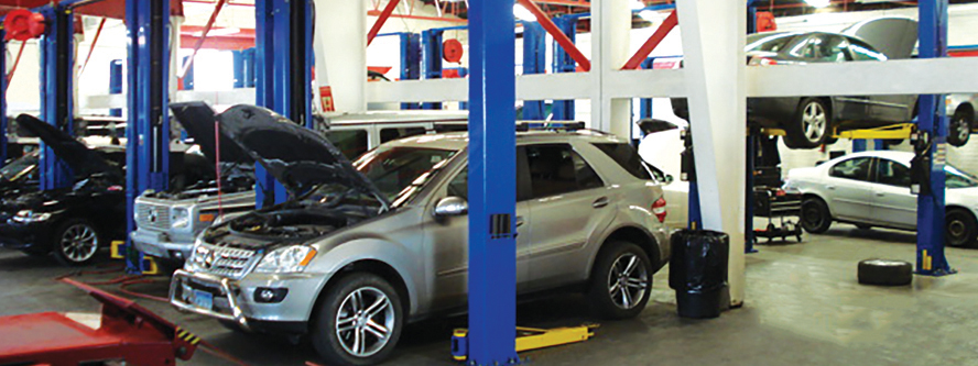 Fotografia del interior de mecanica BCS, demostrando diversos carrros en diferente niveles de reparacion.